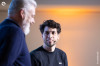 Tristan, de trois-quarts dos, sur la scène de la Duck Conf, avec Romain Taillade qui le regarde